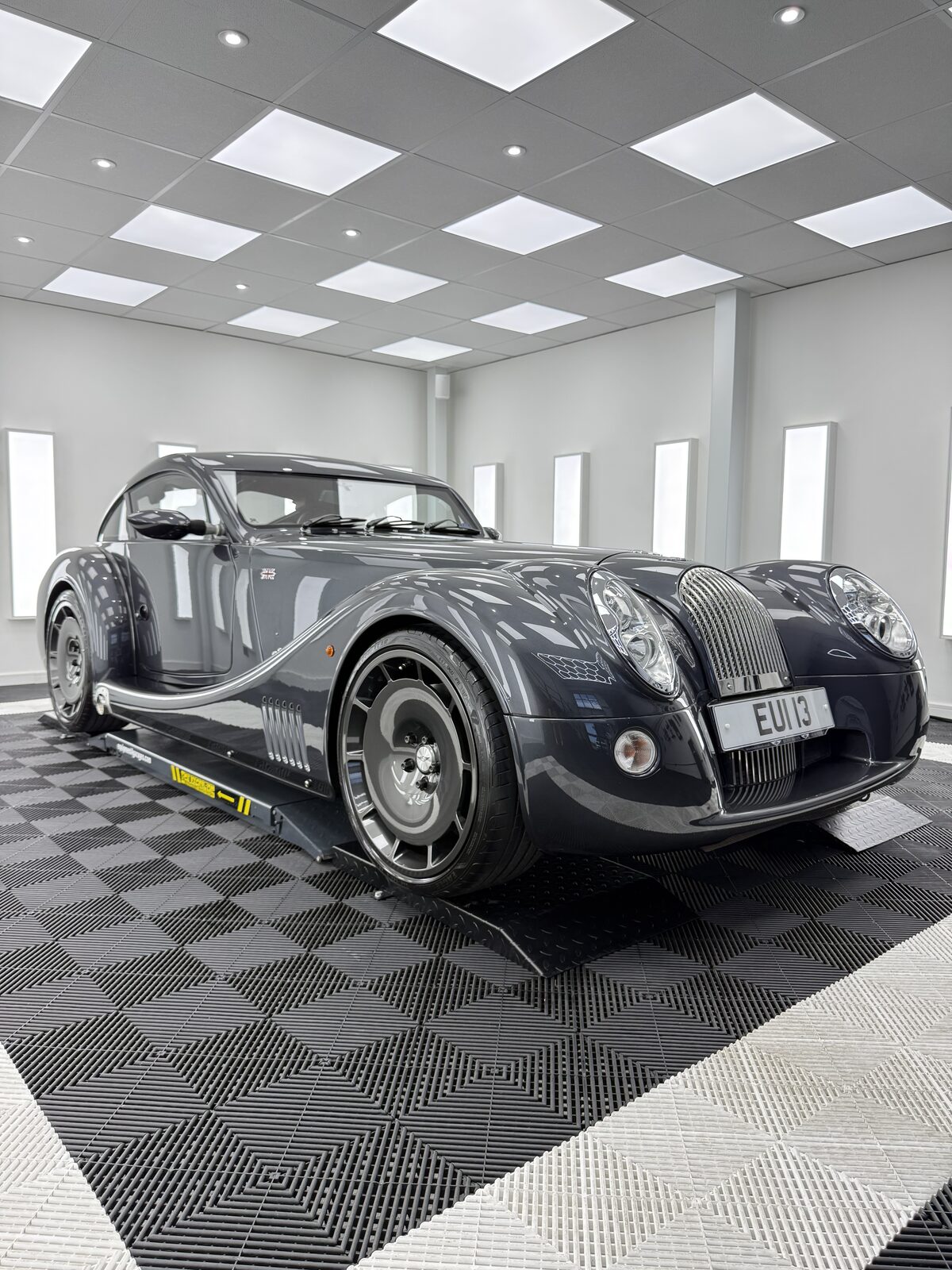 Charcoal Morgan Aero Coupe front three quarter view on a lift in the Elevate Detailing UK studio
