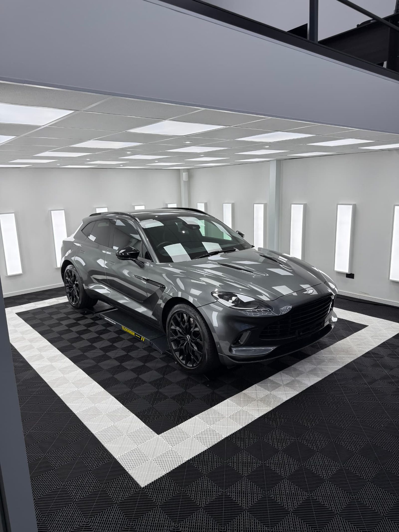 Grey Aston Martin DBX SUV front three quarter view in the Elevate Detailing UK studio in Exeter