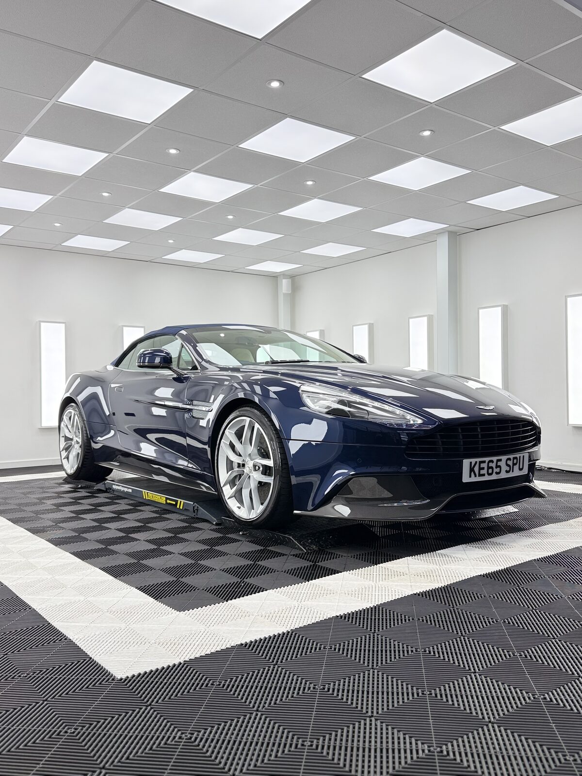 Dark navy Aston Martin Vanquish Volante front three quarter view in the Elevate Detailing UK studio bay